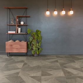 Oak effect flooring in a prisma style laid in a room with dark grey wall and a shelving unit