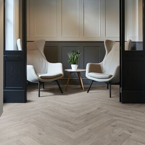 Oak effect flooring laid in a parquet style in a seating area