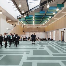  Green safety flooring laid in a pattern in a High school hallway with pupils 