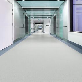 Light colour safety flooring in a long commercial corridor