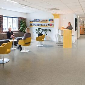 Brown stone effect safety flooring in a seating area with tables and chairs