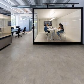 Warm concrete effect flooring laid in a office hub space