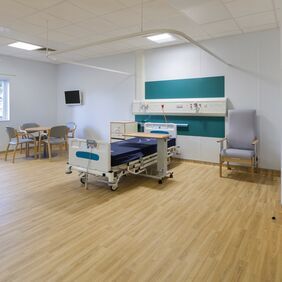 Light wood effect flooring in a large hospital room 