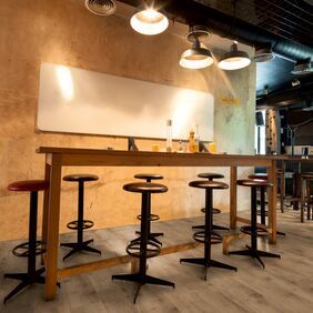 Oak effect flooring laid in a bar area with high table and stools