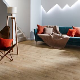 Lounge area with sofa and lamp featuring light wood oak effect flooring in Cashmere Oak random straight laid
