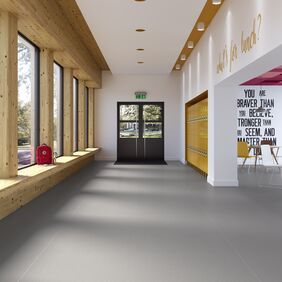 Grey safety flooring in a school corridor