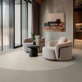 Light coloured cement effect flooring laid in a hotel lobby seating area