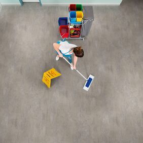 Overhead of a lady cleaning a concrete effect flooring