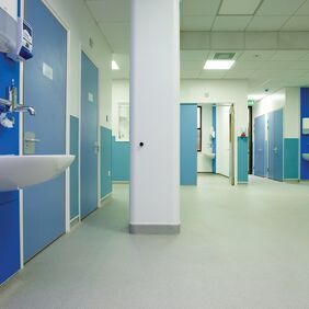 Grey stone effect flooring in a hospital bathroom wash area 