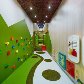 Children's playroom with climbing wall and green flooring