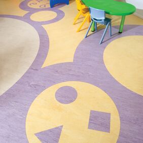Yellow homogeneous flooring in a childrens hospital waiting area with mural flooring designs 