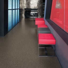 Dark stone effect flooring in a corridor with red and black seats