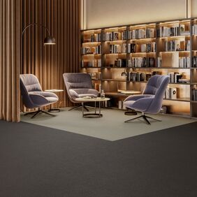 Dark coloured flooring laid in a meeting space with bookshelves
