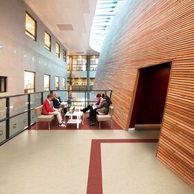 Light stone effect flooring in a seating area with decorative wood slat walls 
