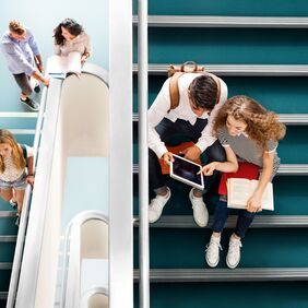 Green safety flooring on a college staircase with people seating down 