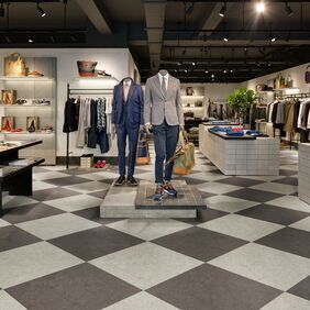 Light grey and dark grey chequerboard laid pattern flooring in a retail store 