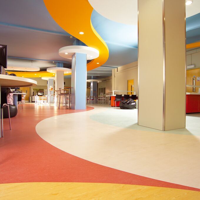 Bright homogeneous flooring laid in various patterns to add colour to hospital canteen