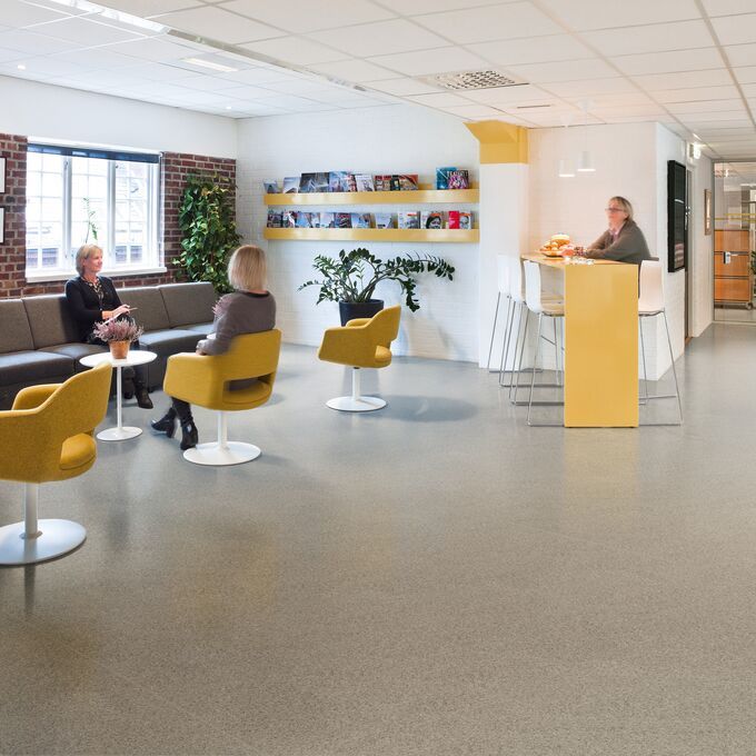 Brown stone effect safety flooring in a seating area with tables and chairs