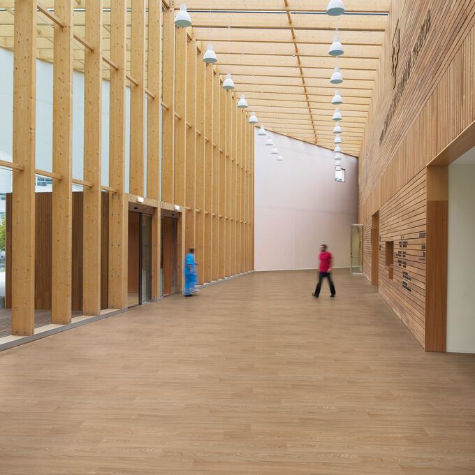 Hospital entrance with wooden walls and frame with oak effect flooring