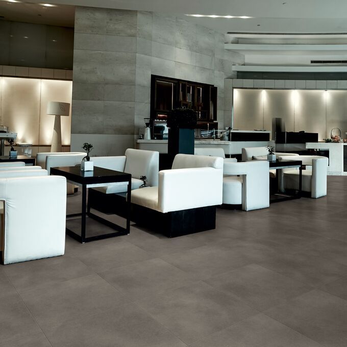 Resturant dining area with stylish white chairs featuring dark concrete effect flooring 