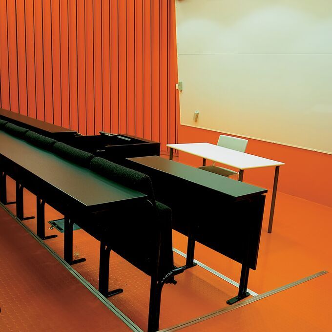 Lecture hall with orange flooring and walls