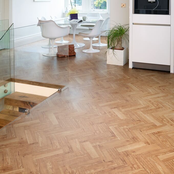 White dining table and chairs, with Nut Tree Oak colour Herringbone design laid floor 