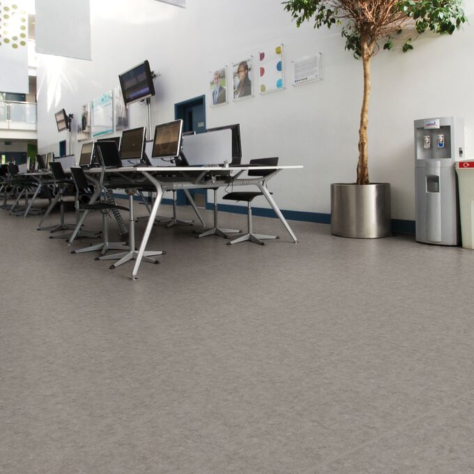 Stone effect safety flooring in a large office space with desk and computers