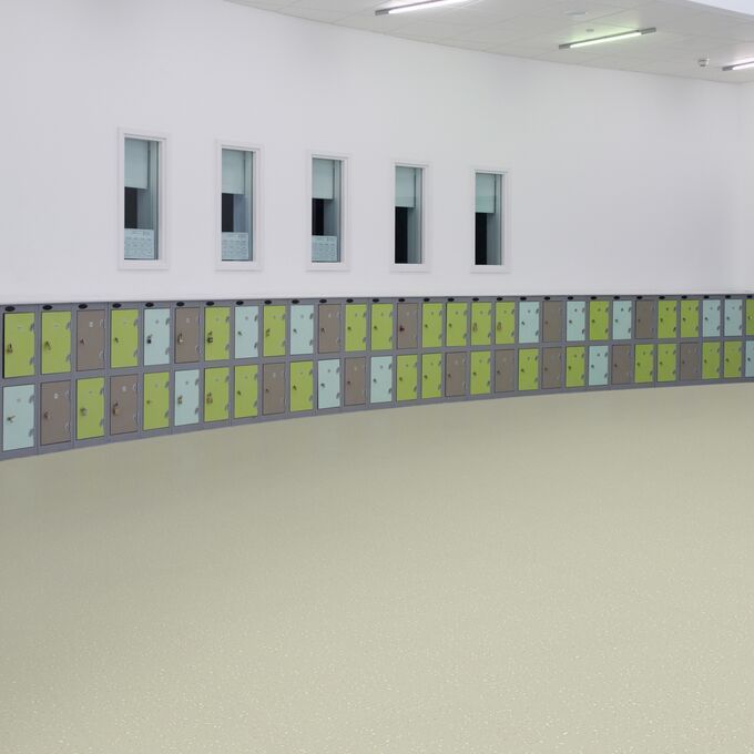 Neutral colour safety flooring in a large open space with lockers 