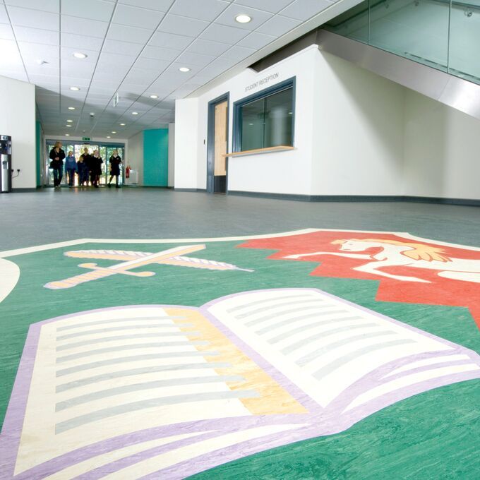 Green colour homogeneous flooring in a highschool corridor with a book Motif 