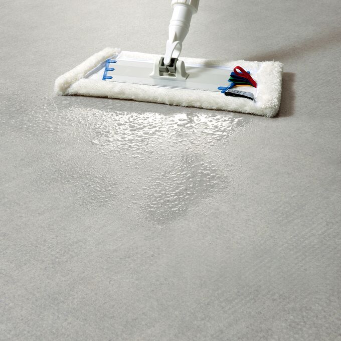 Light grey flooring being cleaning with a mop