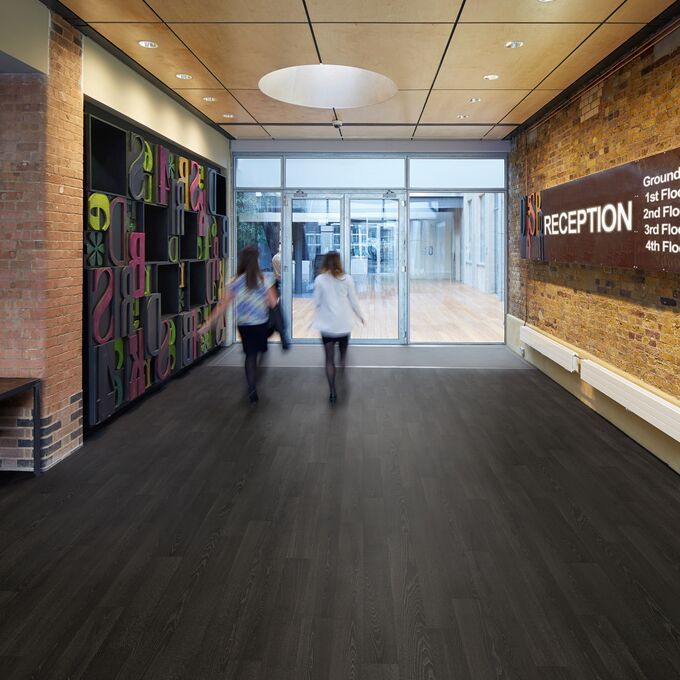 Dark oak wood effect flooring in a education entrance way 