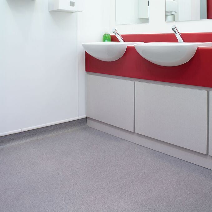 Grey stone effect safety flooring in hospital bathroom 