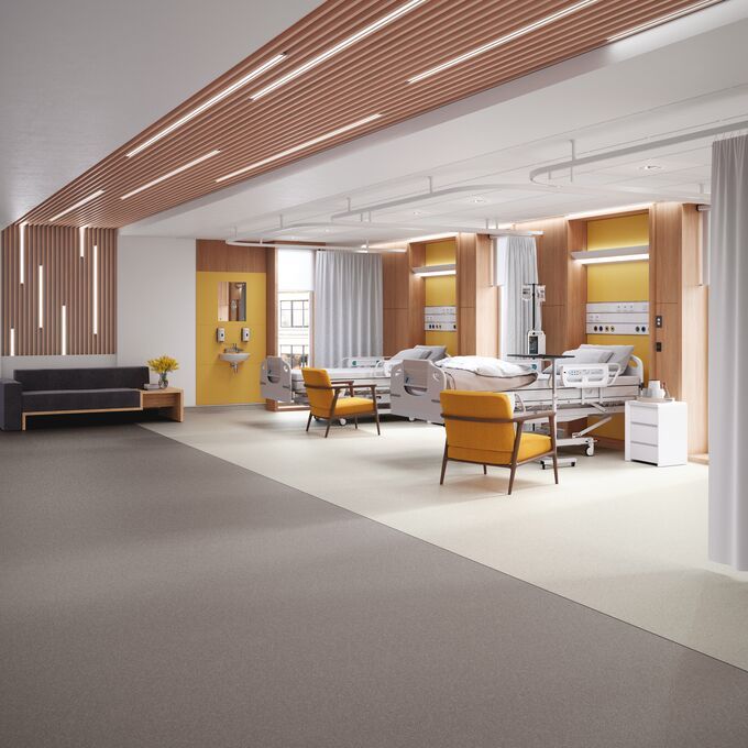 Neutral colour safety flooring in a hospital ward with beds and seats