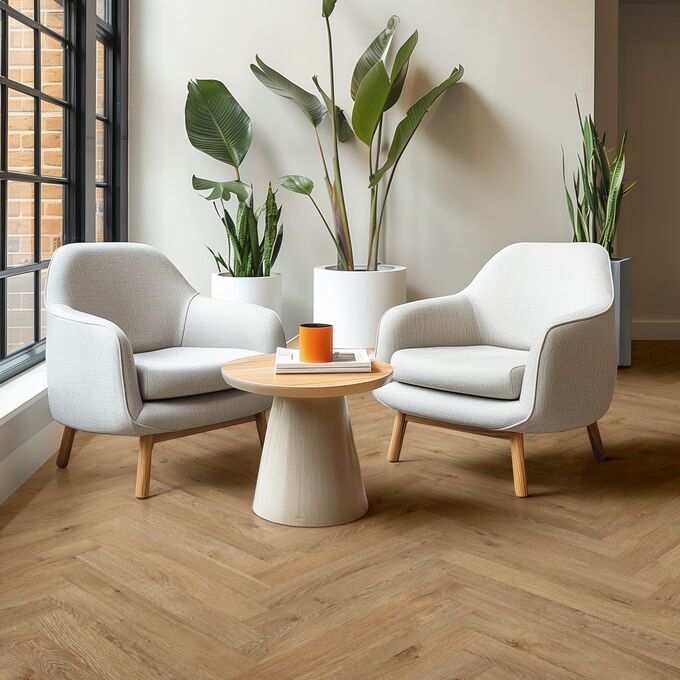 Oak effect parquet flooring laid in a seating area with white chairs and large plants