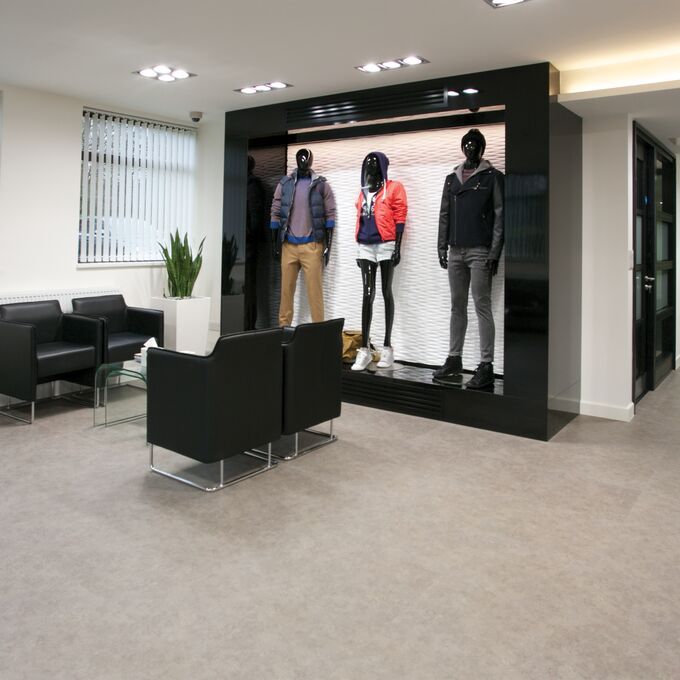 Stone effect flooring in a waiting area with mannequins in appareal wear